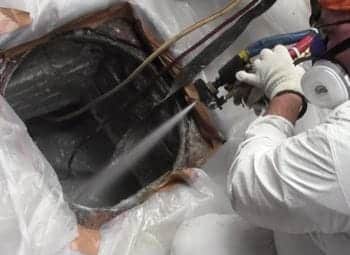 Spraying the top of a sewer manhole 