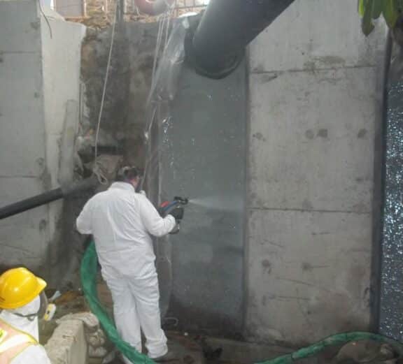 Spraying concrete wall with ArmorThane
