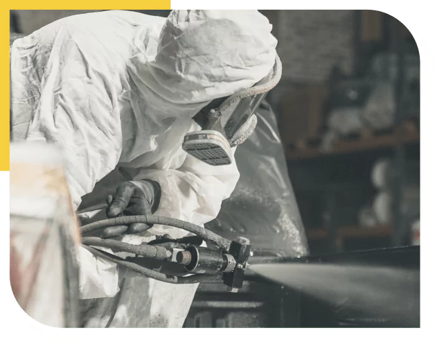 Worker spraying coating in full-body suit