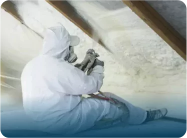 Worker applying spray foam in attic