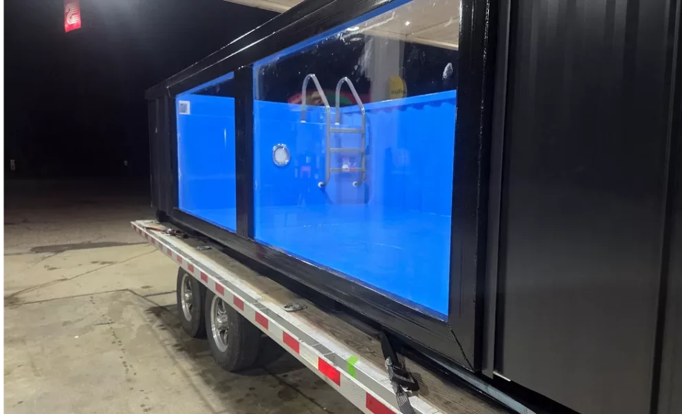ArmorThane polyurea coated shipping container pool with illuminated acrylic window on trailer mobile view